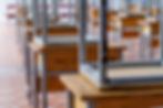 Image of weathered school desks stacked on top of each other in a classroom setting