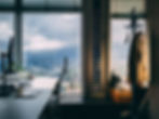 Home office window looking out at a hazy west coast cityscape wtih mountain vires