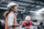 Male and female industrial workers constructing in PPE
